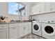 Bright laundry room with white cabinets, granite countertops and patterned tile floor at 29775 E 162Nd Ave, Brighton, CO 80603