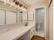 Bathroom with vanity, large mirror, and toilet at 1050 S Monaco Pkwy # 106, Denver, CO 80224