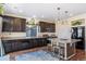 Modern kitchen with dark cabinetry, granite counters, and island at 10789 Troy St, Commerce City, CO 80022