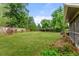 Expansive grassy backyard with a screened porch and wooden fence at 3058 S Galena Ct, Denver, CO 80231