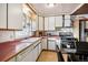 Kitchen with white cabinets, pink countertops, and gas range at 1340 Xanthia St, Denver, CO 80220