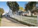 Ranch style home with a white picket fence and driveway at 1340 Xanthia St, Denver, CO 80220