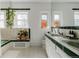 Bathroom with green tile, white vanity, and a corner bathtub at 836 E 17Th Ave # 2E, Denver, CO 80218