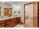 Clean bathroom with double vanity and a view of a bedroom at 7747 S Settlers Dr, Morrison, CO 80465