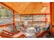 Relaxing covered porch with wooden ceiling, comfortable seating, and wooded views at 7747 S Settlers Dr, Morrison, CO 80465