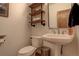 Stylish powder room with pedestal sink, toilet and floating shelves at 7747 S Settlers Dr, Morrison, CO 80465