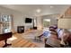 Living room with hardwood floors, a wood burning stove, and leather furniture at 11770 Leavenworth Dr, Conifer, CO 80433
