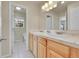 Main bathroom with double sinks, light wood cabinets, and a toilet at 11770 Leavenworth Dr, Conifer, CO 80433