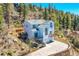 Stunning aerial view of a two-story house with a deck, hot tub, and mountain backdrop at 11770 Leavenworth Dr, Conifer, CO 80433