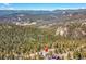 Aerial view of house nestled in mountainous region at 11770 Leavenworth Dr, Conifer, CO 80433