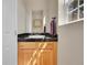 Small bathroom with granite countertop and wood cabinets at 11770 Leavenworth Dr, Conifer, CO 80433