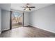 Bedroom with hardwood floors, ceiling fan, and sliding glass door to balcony at 5775 W Atlantic Pl # 303, Lakewood, CO 80227