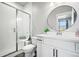 Clean bathroom with white vanity, walk-in shower, and round mirror at 1025 S Gilbert St # C, Castle Rock, CO 80104