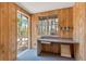 Small office with wood paneling, desk, and window offering a view of woods at 28 Deer Rd, Evergreen, CO 80439