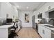 Modern kitchen with white cabinets, stainless steel appliances, and gray backsplash at 2466 S Delaware St # 2, Denver, CO 80223