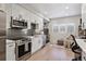 Modern kitchen with white cabinets, stainless steel appliances, and gray backsplash at 2466 S Delaware St # 2, Denver, CO 80223