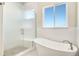 Spa-like bathroom with soaking tub, walk-in shower, and large window at 24113 E 36Th Pl, Aurora, CO 80019