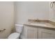 Powder room with single vanity, toilet, and patterned floor at 24113 E 36Th Pl, Aurora, CO 80019