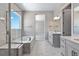 Spa-like bathroom with soaking tub, double vanity, and marble tile at 3893 Freestone Pt, Castle Rock, CO 80108