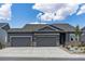 Two-story home exterior with gray siding, three-car garage, and stone accents at 3893 Freestone Pt, Castle Rock, CO 80108