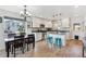 Modern white kitchen with an island, stainless steel appliances, and dining table at 748 Country Road Trl, Berthoud, CO 80513