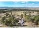 Stunning aerial view of a secluded home nestled among trees with mountain views in the distance at 5519 Ponderosa Dr, Parker, CO 80134