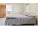 A bedroom with a large bed, carpeted floors, and a door leading to another room at 5519 Ponderosa Dr, Parker, CO 80134
