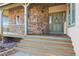 Welcoming front porch with stone accents, wood decking, and a charming front door at 5519 Ponderosa Dr, Parker, CO 80134