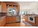 Kitchen with wood cabinets, double sink, dishwasher, and a window overlooking the scenery at 5519 Ponderosa Dr, Parker, CO 80134