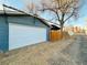 Attached garage with white door and gravel driveway at 4208 S Sherman St, Englewood, CO 80113