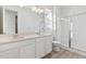 Bathroom with double vanity, white cabinets and a glass shower at 9723 Ceylon St, Commerce City, CO 80022
