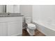 Bathroom with white cabinets, granite countertop, and a bathtub at 2225 Alyssa St, Fort Lupton, CO 80621