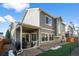 Two-story home with gray siding and backyard patio at 10226 Worchester St, Commerce City, CO 80022
