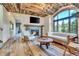 Spacious living room with stone fireplace, hardwood floors, and large windows offering scenic views at 3864 Valley Dr, Evergreen, CO 80439