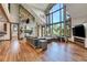 Spacious living room with hardwood floors, stone fireplace, and large windows offering scenic views at 3864 Valley Dr, Evergreen, CO 80439