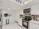 Bright kitchen features white cabinetry, stainless steel appliances, and a view to the living room at 7640 S Monaco Cir, Centennial, CO 80112