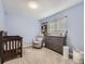 Charming Bedroom featuring a crib, dresser, and comfortable armchair at 7640 S Monaco Cir, Centennial, CO 80112
