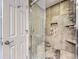 Bathroom with shower, tile surround, and built-in shelving at 7640 S Monaco Cir, Centennial, CO 80112