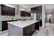 Modern kitchen with dark cabinetry, white countertops, and stainless steel appliances at 7030 S Buchanan St, Aurora, CO 80016