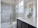Modern bathroom with a large walk-in shower, tile flooring, and a vanity with a quartz countertop at 7030 S Buchanan St, Aurora, CO 80016