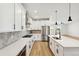 Modern kitchen with white cabinets, stainless steel appliances, and herringbone backsplash at 42986 Colonial Trl, Elizabeth, CO 80107