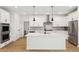 Modern kitchen with white cabinets, island, and herringbone backsplash at 42986 Colonial Trl, Elizabeth, CO 80107