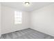 Unfurnished bedroom featuring gray carpeting and a large window at 1562 Farmstead St, Brighton, CO 80601