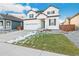 Inviting two-story home with white siding, black accents, and a neatly landscaped yard at 1562 Farmstead St, Brighton, CO 80601