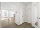 Bright foyer with wood-look flooring, coat closet, and view of the living area at 1562 Farmstead St, Brighton, CO 80601