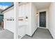 Welcoming front porch with a black front door, modern light fixtures, and an attached garage at 1562 Farmstead St, Brighton, CO 80601