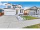 Front exterior of the home with a driveway and landscaping at 1562 Farmstead St, Brighton, CO 80601