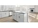 Kitchen island with dark countertop, white cabinets, and sleek hardware at 1562 Farmstead St, Brighton, CO 80601