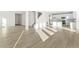 Open-concept living area with wood-look flooring, abundant natural light, and a view of the kitchen at 1562 Farmstead St, Brighton, CO 80601