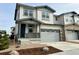 Two-story townhome with gray siding, two-car garage, and small front yard at 6604 N Malta St, Aurora, CO 80019